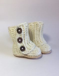 a pair of white crocheted boots with buttons