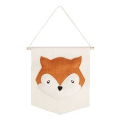 an orange and white wall hanging with a fox face