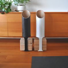 two vases sitting next to each other on top of a wooden floor in front of a dresser