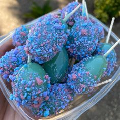 blue and pink sprinkled cake pops in a plastic container