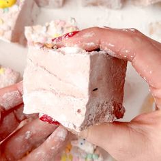 two hands are holding a piece of cake with sprinkles on it and the other hand is grabbing one