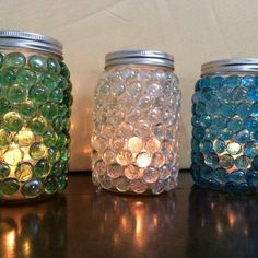 three jars with different colored glass beads on them