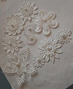 some white lace flowers and pearls on a piece of paper