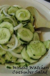 a white bowl filled with sliced cucumbers and onions on top of a table