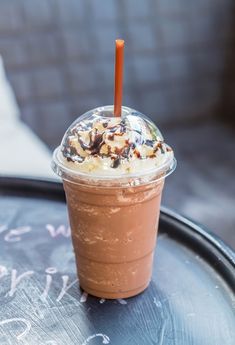 a chocolate drink with whipped cream and toppings on the top is sitting on a table