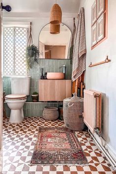 the bathroom is decorated in pink and green tones, with an ornate rug on the floor