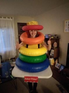 a woman is standing in front of a stack of floating rafts that are stacked on top of each other