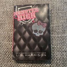 a black book with a pink bow on it sitting on top of a carpeted floor