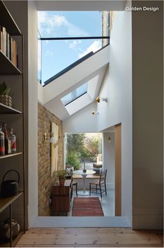 an open living room with a skylight above the dining table and bookshelf