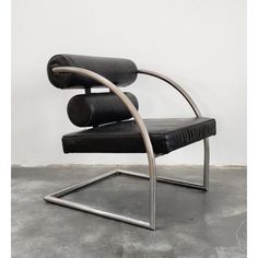 a black leather chair sitting on top of a cement floor