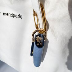 a close up of a key chain attached to a white bag with the word mercipars on it