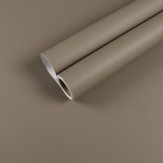 two silver tubes on a brown surface