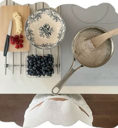 a pan with blueberries and raspberries in it next to other kitchen utensils