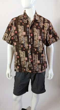 a male mannequin wearing a brown shirt and black shorts with multicolored squares on it