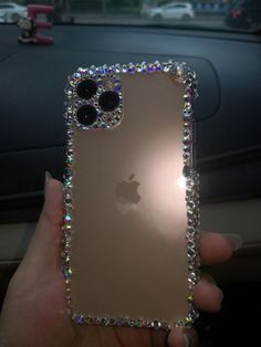 someone is holding up an iphone case with lots of crystals on it in their hand