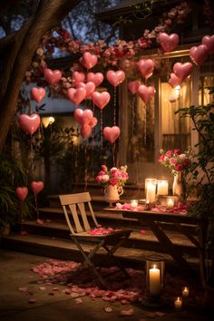 candles and flowers are on the steps outside with hearts floating in the air above them