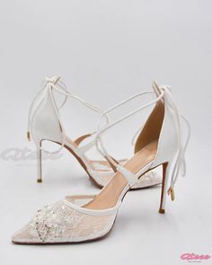 a pair of white high heel shoes with lace