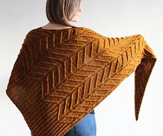 a woman wearing a brown knitted shawl with an intricate design on the back