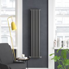 a modern radiator in a living room next to a chair and table with a potted plant