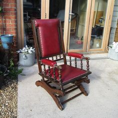 a red leather rocking chair sitting on top of a patio