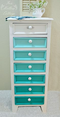 a white and blue dresser with drawers