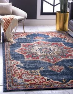 a blue rug with red, yellow and white designs on it in a living room