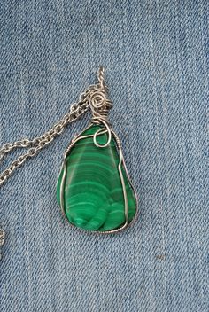 This vivid green pendant necklace was created by us from rough chunks of natural Congo malachite. We shaped and polished it, then used stainless steel wire to create the pendant. We completed the necklace with stainless steel chain and findings. Malachite is a copper carbonate hydroxide and it is the copper that gives it that lush green color. Some say that malachite is good for absorbing negative energy and helps both the throat and the heart chakras. Treat yourself to a beautiful and unique addition to your jewelry collection! Necklace length-appx. 25 inches Pendant length-appx. 2.4 inches Malachite specimen dimensions-appx. 1.5 x 1.1 x 0.4 inches Thank you for shopping with small business! Love this wire wrapped malachite pendant? Please check out our other creations on our Etsy Home Pa Luxury Handmade Malachite Necklace, Green Malachite Wire Wrapped Jewelry, Green Pendant Necklace, Green Stone Pendant, Wedding Lookbook, Green Pendant, Malachite Pendant, Malachite Jewelry, Green Pendants