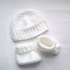 Newborn to 3 months. This is a little crocheted baby white hat and booties set. Suitable for both baby girls or baby boys. The yarn is a medium weight acrylic, and this is an ideal baby shower gift. Machine wash and dry, short gentle cycle, low heat, or hand wash and dry flat. Please read my policies and FAQ for more information. To view more of my items .... www.etsy.com/shop/lurayknitwear To visit my other Etsy shop for adult hats, scarves, mittens .... www.etsy.com/shop/Pageknitwear Shipping Infant Crochet, Crochet Baby Sweater Sets, Baby Pom Pom Hat, Crochet Baby Beanie, Knitted Baby Cardigan, Knit Baby Booties, Haken Baby, Crochet Set, Crochet Baby Clothes