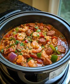 a crock pot filled with shrimp and rice