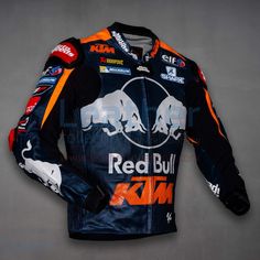 the red bull racing suit is displayed on a gray background with an orange and white stripe