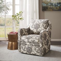 a living room with a chair and a vase on the floor next to a window