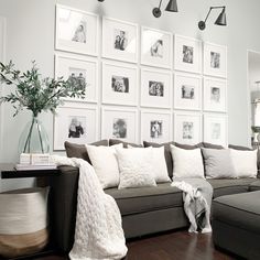 a living room with pictures on the wall and a dog in front of it's couch