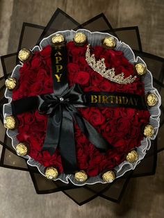 a birthday cake decorated with red roses and chocolates