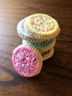 three crocheted coasters sitting on top of a wooden table