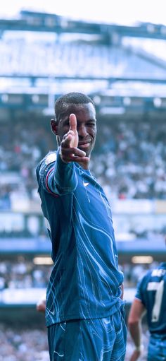 a man giving the thumbs up sign at a football game