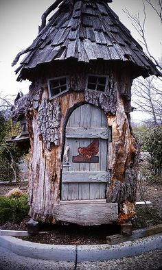 an old tree stump with a door and window in the shape of a shoe on it