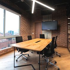 an empty conference room with brick walls and large windows