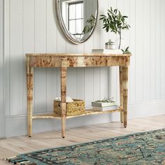 a wooden table with a mirror above it and a plant on top of the table