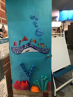 a bulletin board with an image of a whale and corals in the ocean on it