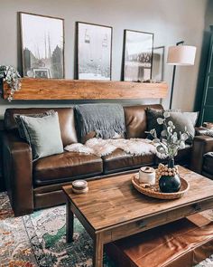 a living room with leather couches and coffee table in front of the window, framed pictures on the wall