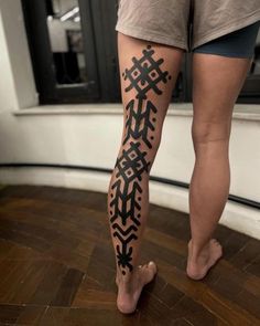 a woman's legs with tattoos on them, and her leg in the shape of a cross