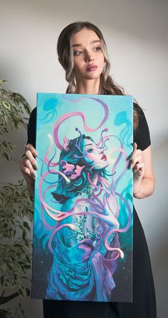 a woman holding up a painting with an octopus on it