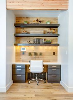 a home office with built - in shelving and wooden flooring, along with a white chair