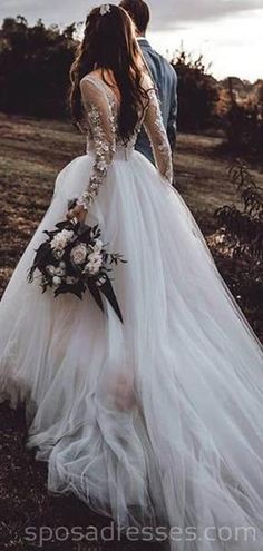 a bride and groom standing in the middle of a field