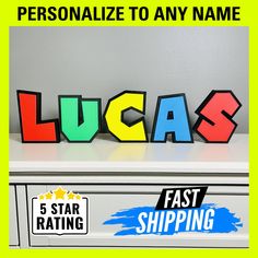 the word lucas spelled out in colorful letters on top of a filing cabinet with five star shipping stickers