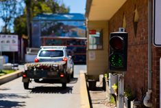 a traffic light sitting on the side of a road next to a street with cars