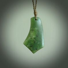 a green stone pendant hanging from a rope