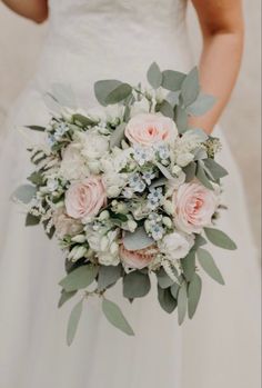 a bridal holding a bouquet of flowers and greenery