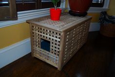 a plant is sitting on top of a wooden box with a hole in the side