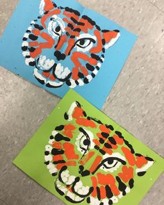 two pictures of tiger faces are on the floor next to each other, one is painted with acrylic paint